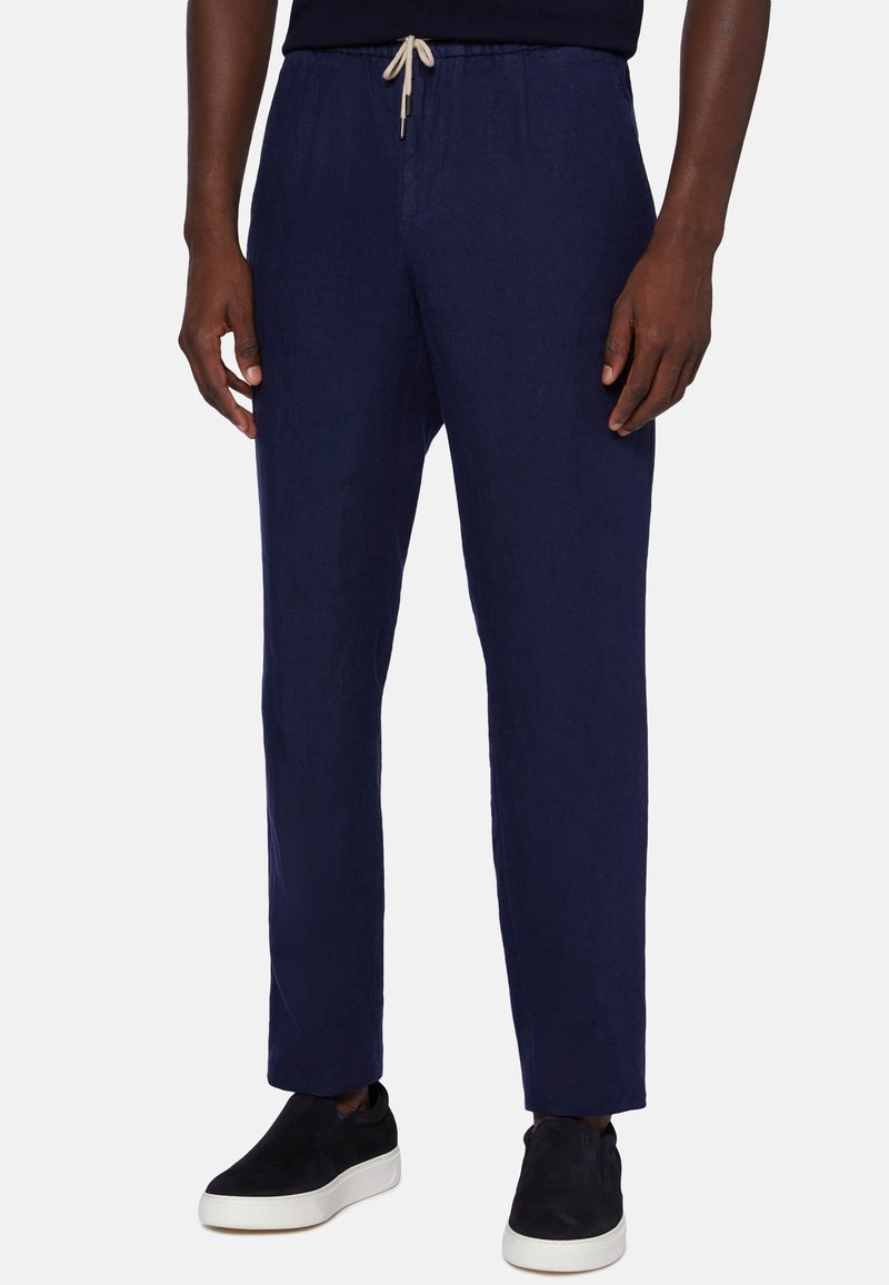 Marina linnebyxor med dragsko i midjan, raka ben, sidfickor och matchade med svarta slipskor.