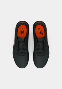Black athletic shoes with orange accents, lace-up design, smooth texture, and logo on insole. Features perforations for ventilation.