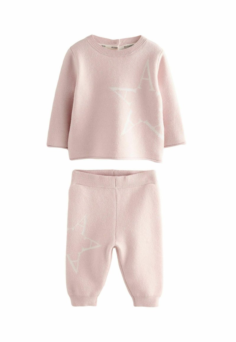 Ružový pletený dvojdielny set pozostávajúci z topu s dlhým ruk�ávom, ktorý má bielu hviezdu a dizajn písmena "A", doplnený o zodpovedajúce zúžené nohavice.