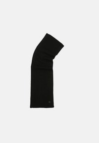 Sort strikescarf med en ribbet tekstur, forlænget form og et subtilt logo-tag i bunden. Designet har en skråtstillet top.