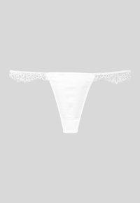 Άσπρο δαντελένιο στρινγκ εσώρουχο με λουλουδάτη δαντέλα στα πλαϊνά, τοποθετημένο επίπεδα πάνω σε ανοιχτό γκρίζο φόντο.