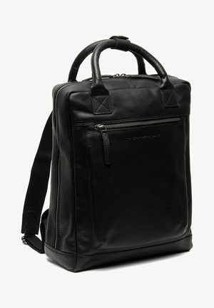 Sac à dos en cuir noir avec deux poignées supérieures, des bretelles ajustables, une poche zippée à l'avant et un design minimaliste. Texture lisse et matériel robuste.
