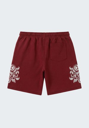 Bordeauxkleurige shorts met elastische taille, witte bloemmotieven op elke poot en een enkele achterzak aan de rechterkant.