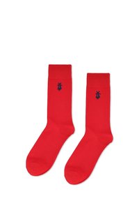 Czerwone bawełniane skarpetki o gładkiej fakturze, z małym granatowym logo po boku. Skarpetki mają klasyczny kształt i długość do połowy łydki.