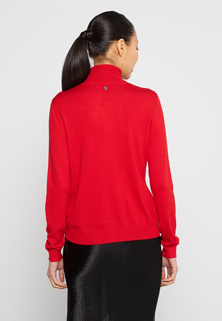 Maglione rosso a collo alto realizzato in tessuto morbido, con maniche lunghe e vestibilità aderente, dotato di un piccolo logo sulla parte posteriore del collo.