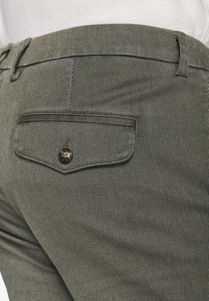 Kaki gestreifte Hose mit einer Gesäßtasche mit Knopfverschluss; glatte Textur, taillierte Passform, subtile vertikale Linien im Stoff.