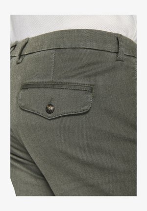 Khaki striped pants with a back pocket featuring a button closure; smooth texture, tailored fit, subtle vertical lines in the fabric.