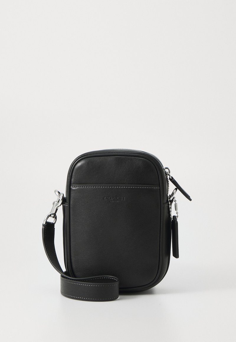 Black leather crossbody bag with a rectangular shape, smooth texture, silver hardware, adjustable strap, and subtle logo on the front.