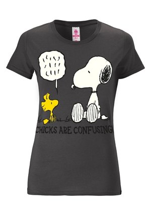 T-shirt noir ajusté avec les personnages de dessin animé Snoopy et Woodstock en train de parler, avec le texte en dessous disant "Les filles sont déroutantes !"
