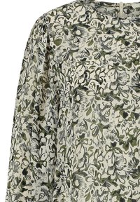 Bloemige blouse in lichtcrème met groene en zwarte patronen. Heeft een zachte stof, ronde halslijn en geplooide mouwen. Sluiting met sleutelgat achter.