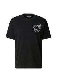 Maglietta nera in cotone con un disegno di cuore bianco con linee tratteggiate sul lato sinistro del petto. Scollo tondo e maniche corte.