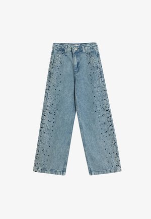 Jasnoniebieskie dżinsy w szerokim kroju z dekoracjami w srebrnym i czarnym kolorze rozmieszczonymi wzdłuż zewnętrznych szwów. Klasyczny krój pięciu kieszeni.