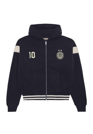 Navy blue zip-up hoodie with hood, white stripes on sleeves and hem, "10" patch on left chest, and circular emblem with two stars on right chest.