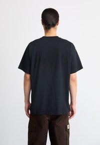 Sort bomulds t-shirt med korte ærmer og rund halsudskæring, der har en glat tekstur og en afslappet pasform, set bagfra.