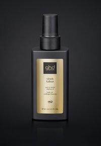 Bouteille en plastique noir au fini mat, avec une étiquette dorée et un texte noir. Contient 95 ml d'huile coiffante de texture humide à lisse.