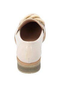 Zapato de charol color beige con punta redonda, detalle de cuerda trenzada en el tacón y suela a rayas. Textura suave y diseño ligero.