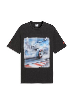 Schwarzes Puma-T-Shirt mit einem Bewegungsunschärfe-Motiv eines Formel-1-Autoreifens auf einer Rennstrecke unter einem stürmischen Himmel mit Blitz.