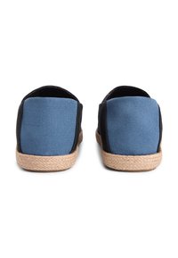 Καμβά παπούτσια σε μπλε και μαύρο χρώμα με σόλα από πλεκτό τζούτ. Διαθέτουν χαμηλή πίσω πλευρά για ευκολία στο φόρεμα. Υλικό με υφή στο πάνω μέρος.