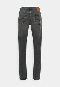 Svarta denimjeans med rak passform, som har två bakfickor, kontrasterande sömmar och en brun läderpatch vid midjan.