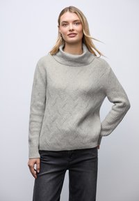 Pull gris clair en maille avec col bénitier, présentant un motif en losanges texturé, poignets côtelés et coupe décontractée. Assorti à un jean foncé.