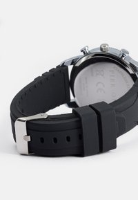 Cinturino in gomma nera con fibbia e dettagli in metallo silver, dotato di fondo in acciaio inossidabile e pulsanti cronografici.