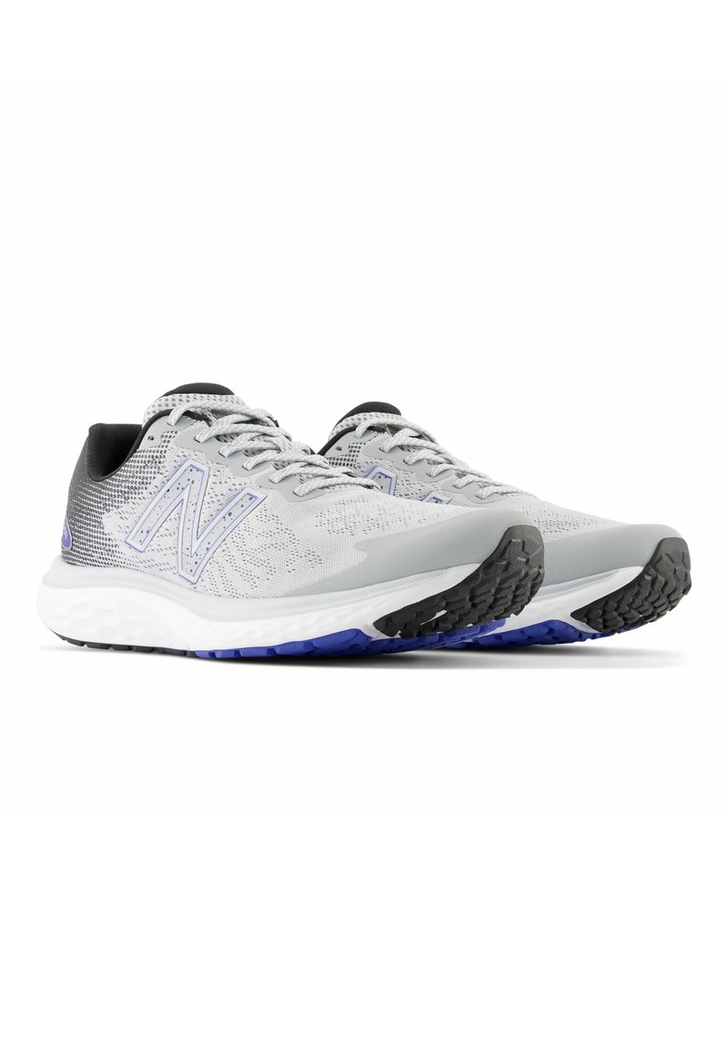 Zapatillas de correr ligeras en gris con detalles en negro y morado. Cuentan con una parte superior de malla transpirable, una mediasuela acolchada y una suela exterior de goma texturizada.