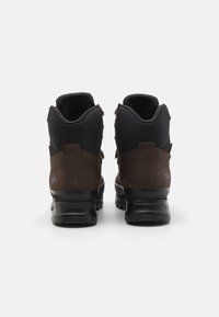 Bottes de randonnée montantes marron et noires avec une finition en cuir texturé, un col rembourré et une semelle épaisse à motif pour une meilleure traction. Accents réfléchissants visibles.