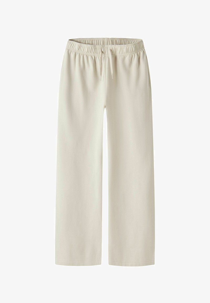 Bež široke športne hlače s širokim pasom iz elastike in vrvico za zavezovanje. Mehka tkanina z gladko teksturo, brez vidnih žepov ali vzorcev.