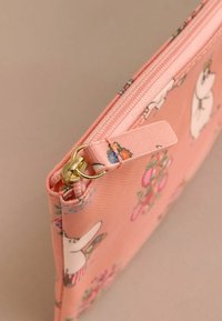 Rožinė audinio piniginė su gėlių raštais ir animaciniais personažais. Su auksine užtrauktuku ir tekstūruota paviršiumi. Kompaktiška ir stačiakampė forma.