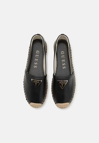 Zwarte leren espadrilles met een jute zool. Kenmerken zijn een driehoekig logo-accent en stiksels langs de randen. Glad oppervlak met een plat ontwerp.