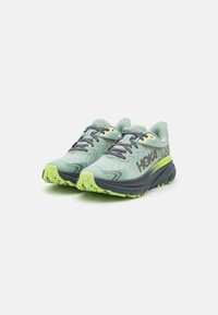 Baskets de course vert clair avec une tige en mesh, des accents gris et une semelle texturée dotée de crampons en caoutchouc vert vif pour la traction.