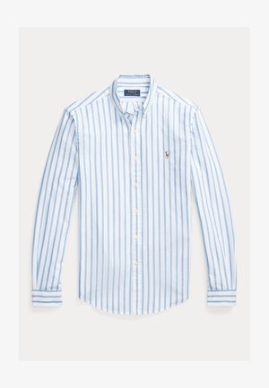 Långärmad skjorta med knappar, ljusblå och vita ränder, bomullsmaterial, rundad fåll och en liten emblem på vänster bröst.