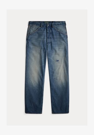 Μπλε τζιν παντελόνια με χαλαρή εφαρμογή, με ξεθωριασμένες περιοχές, ένα αυτοκόλλητο στο αριστερό μηρό και ορατές ραφές.