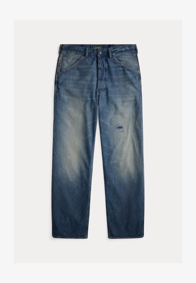 Μπλε τζιν παντελόνια με χαλαρή εφαρμογή, με ξεθωριασμένες περιοχές, ένα αυτοκόλλητο στο αριστερό μηρό και ορατές ραφές.