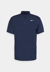 Námorně modrá polo košile vyrobená z hladké látky, s třemi knoflíky na průkrčníku a bílým logem Nike na levé hrudi. Krátké rukávy.