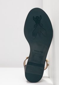 Suola di scarpa nera con un motivo testurizzato e logo inciso. Presenta accenti dorati e una superficie liscia. Taglia 37, made in Italy.