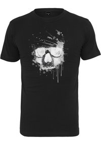 T-shirt noir à manches courtes en coton avec un design de crâne blanc portant des lunettes et des effets de projection, présentant une impression graphique texturée.