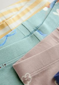 Conjunto de cuatro prendas de algodón con rayas amarillas, verde menta con patrón azul, rosa claro y acentos en azul marino. Texturas suaves y colores variados.