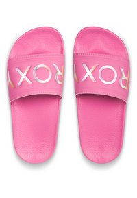 Pink slide sandals made of textured synthetic material with a wide strap featuring the word "ROXY" in iridescent lettering.