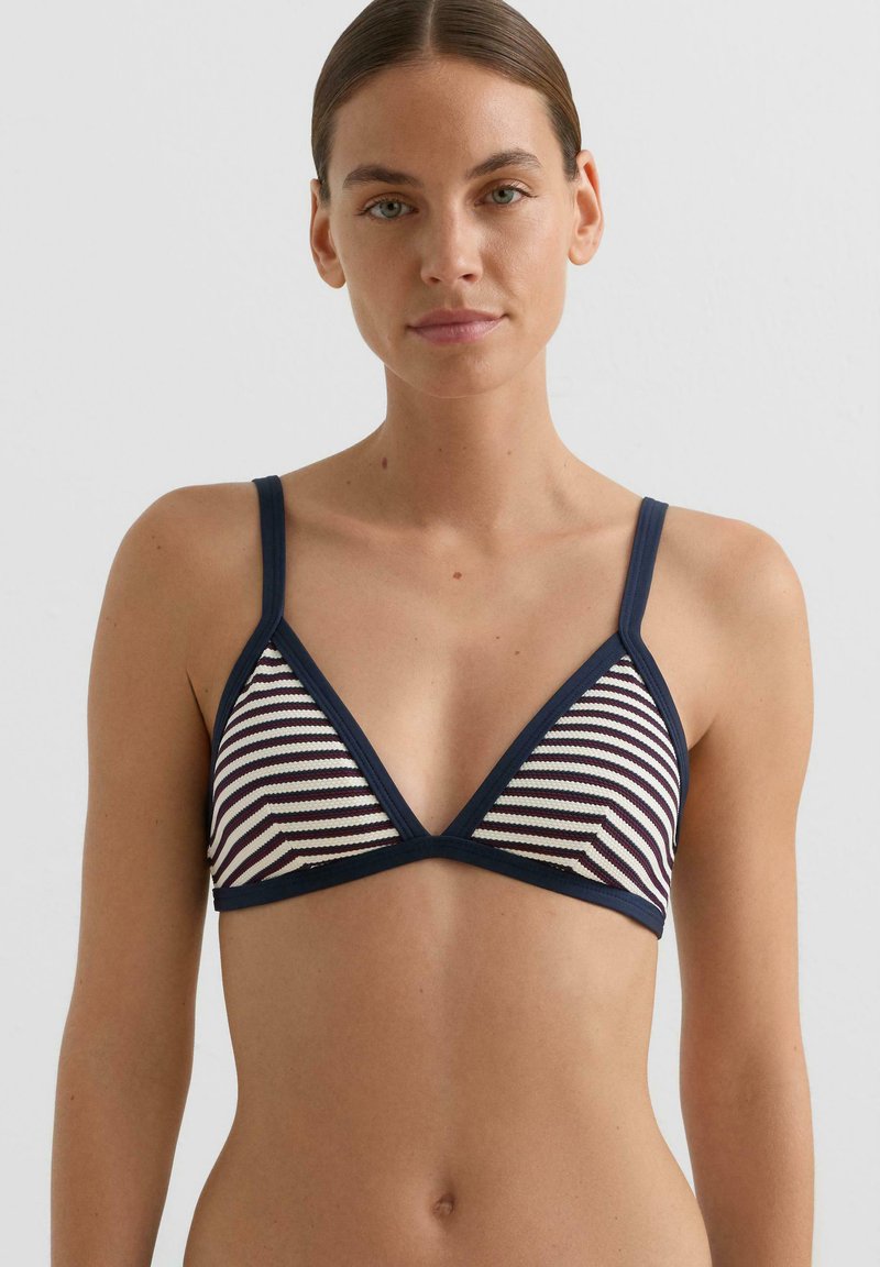 Hajóscsíkos, háromszög alakú bikini felsőrész tengerészkék és krémszínben, állítható pántokkal, sima textúrával és kontrasztos sötét szegéllyel.