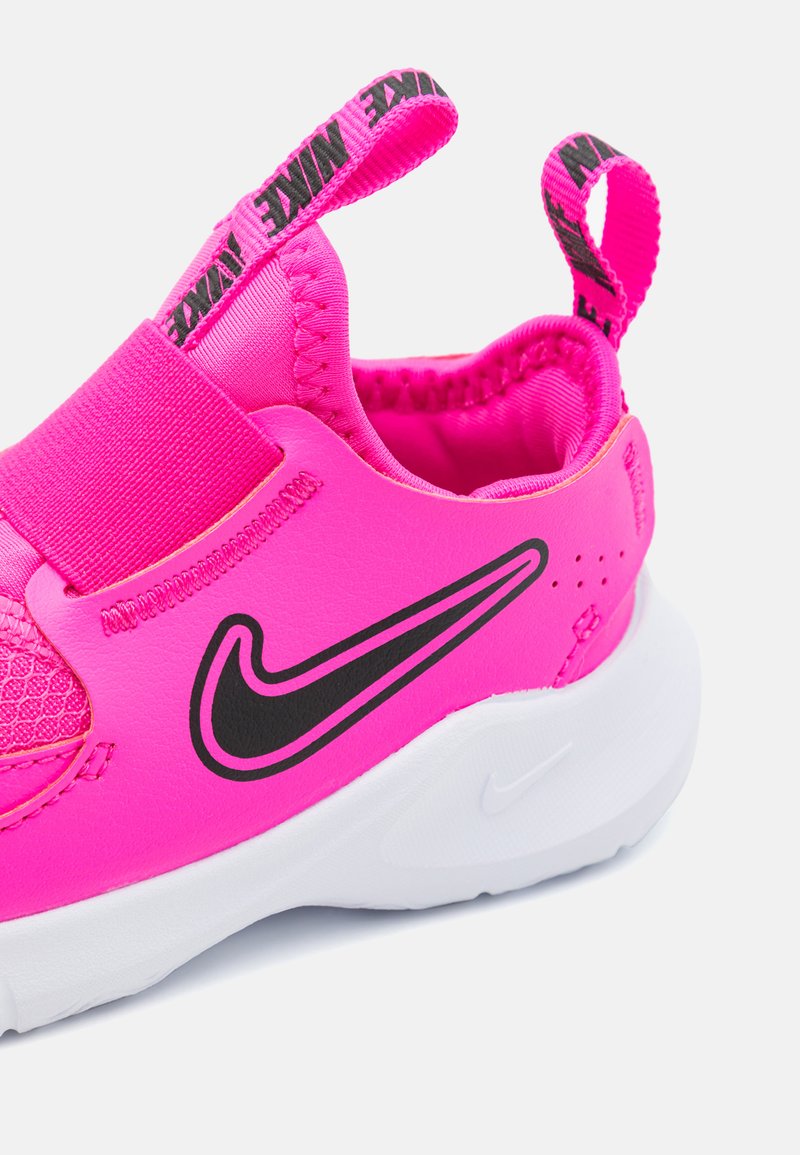 Chaussure de sport rose avec un dessus en mesh et synthétique respirant, une sangle élastique, un logo noir contrastant et une semelle intermédiaire blanche.
