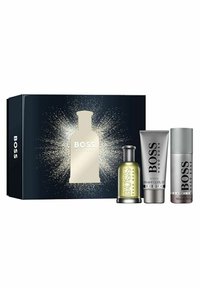 Hugo Boss lahjapakkaus tummansinisessä laatikossa, jossa hopeisia yksityiskohtia, sisältäen vihreän pullon, harmaan tuubin ja hopeapullon, kaikki merkitty "BOSS".
