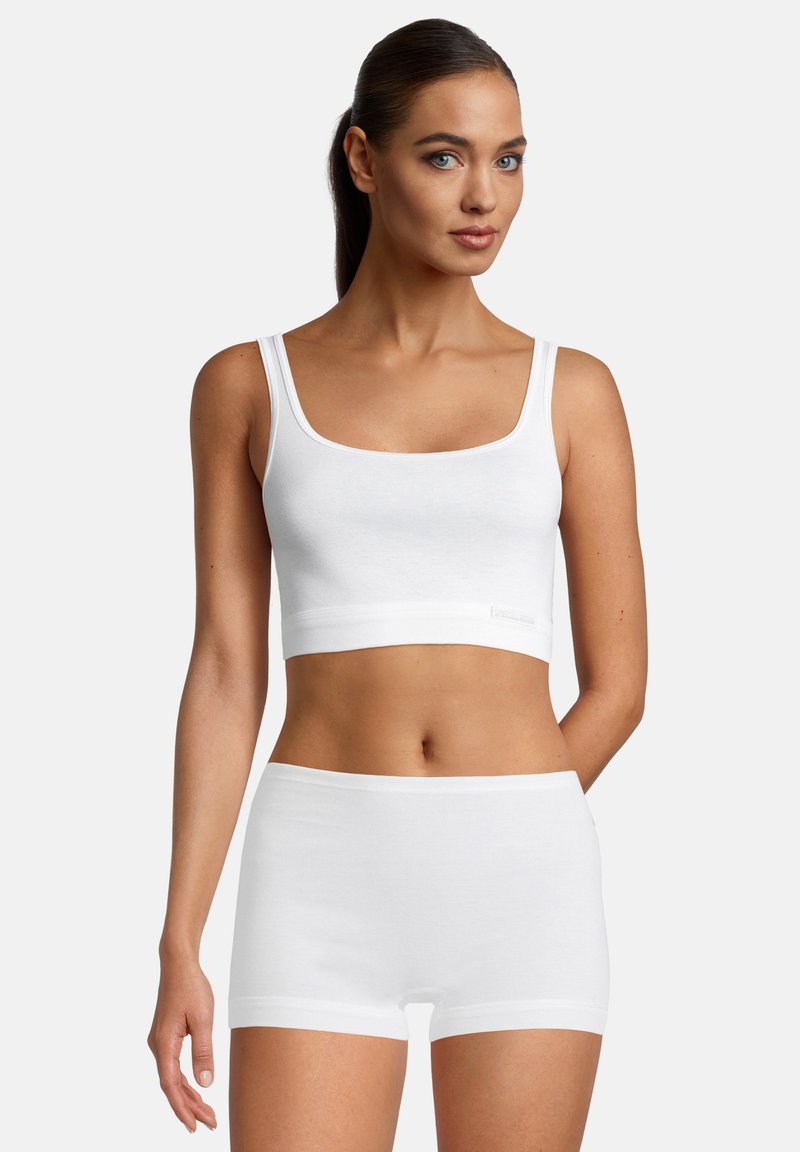 Weiße Baumwoll-Camisole mit quadratischem Ausschnitt und breiten Trägern, kombiniert mit passenden weißen Baumwollshorts mit einem einfachen elastischen Bund.