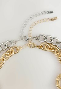 Metallkettchen mit verflochtenen Silber- und Goldglieder, die unterschiedliche Texturen aufweisen, und einem Verschlussmechanismus für einen sicheren Halt.