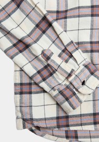 Crème flanellen overhemd met een zwart, bruin en blauw ruitpatroon. Voorzien van knopenmanchetten en een gebogen zoom voor een ontspannen pasvorm.