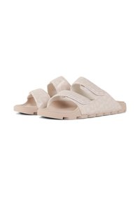 Light beige slide sandals with two wide adjustable straps, textured footbed, and patterned rubber outsole. Smooth, glossy finish.