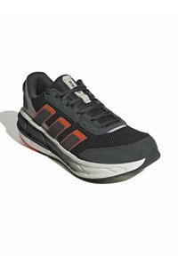 Chaussure de sport noire et grise avec dessus en mesh, semelle épaisse, accents orange et lacets noirs. Présente trois bandes sur le côté et des motifs texturés.