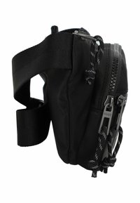Schwarze Nylon-Tasche mit Reißverschlussfach, verstellbarem Riemen und strukturierten Details. Mit einem Log etiquetas und kontrastierenden Hardware-Akzenten.