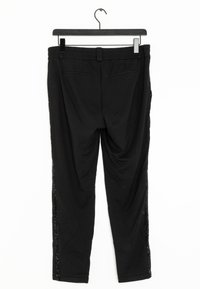 Pantalon noir avec une ceinture élastique comportant des panneaux latéraux en matériau brillant. Texture lisse, conception de jambes fuselées avec deux poches arrière.