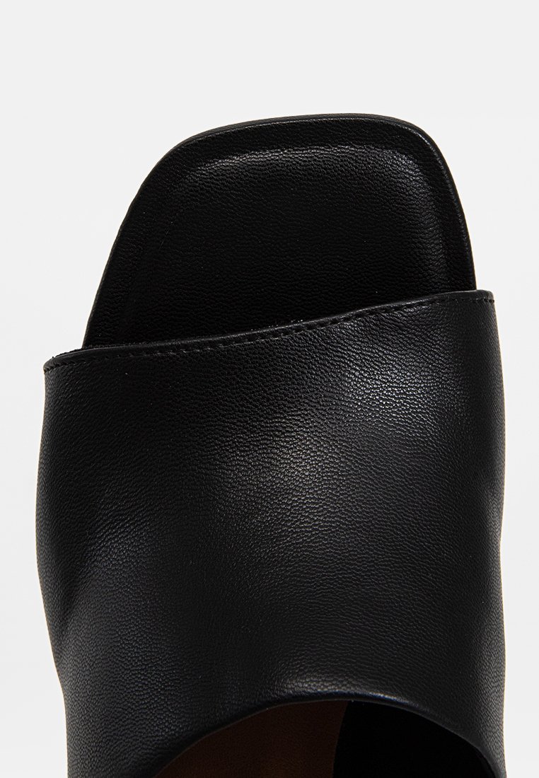 Zwarte leren slipper met een open teenontwerp, een gladde textuur en een brede bovenste band met een vierkante neusvorm.